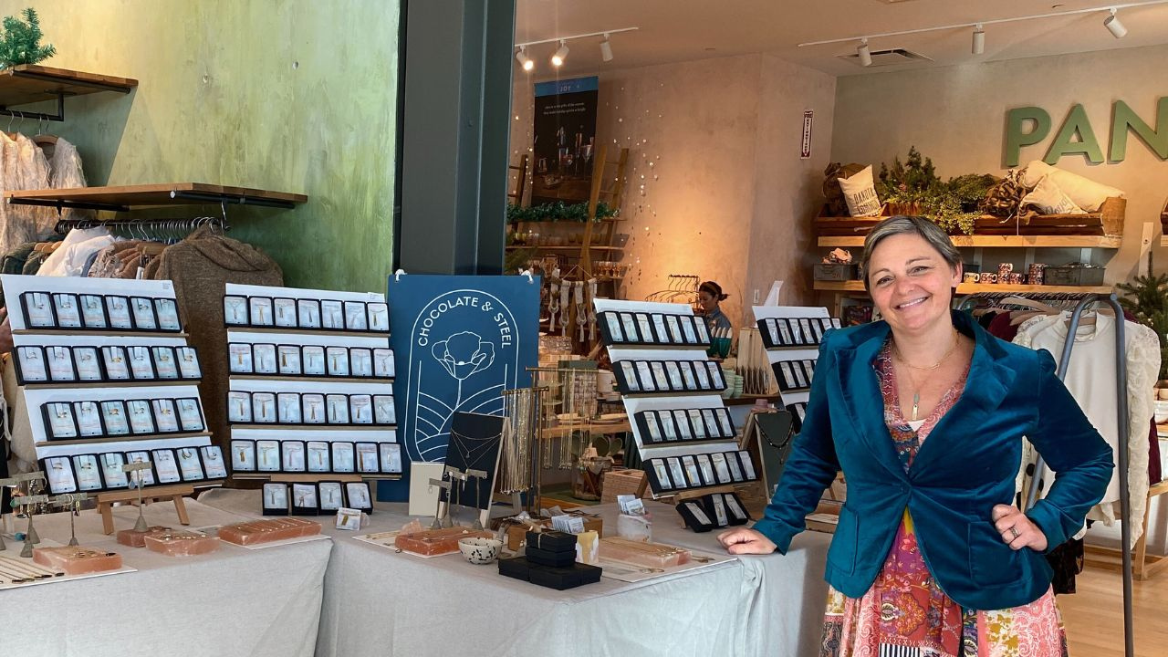 Chocolate and Steel Founder and Creative Director Christine Street stands in front of a table of her jewelry displayed at Anthropologie