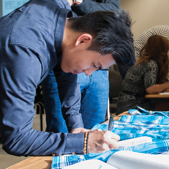 Student laying pattern on fabric